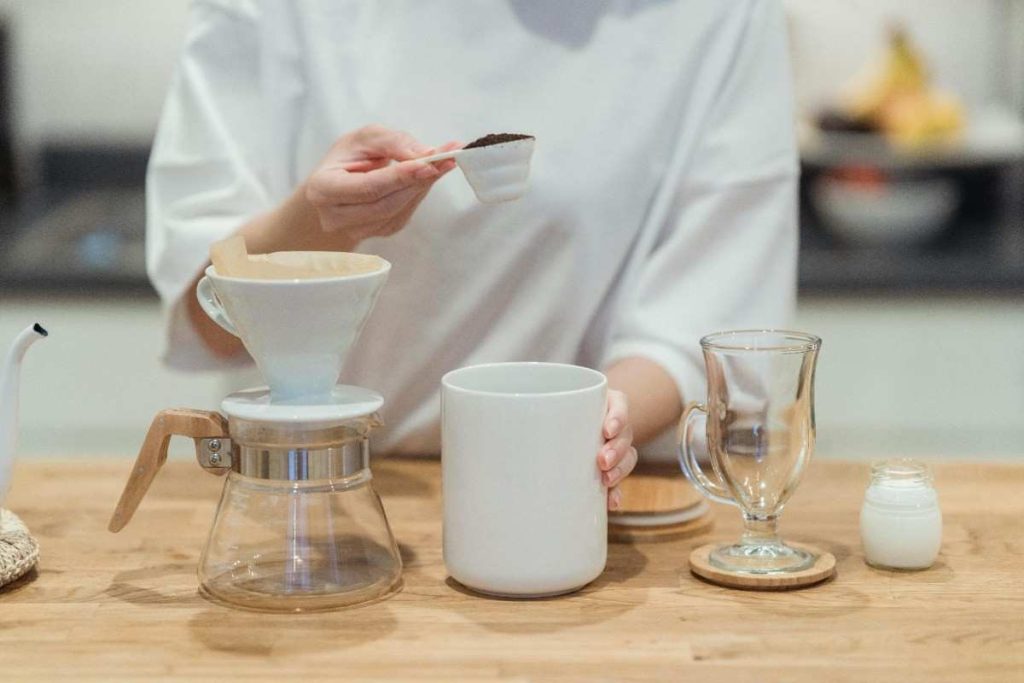 person measuring coffee grounds