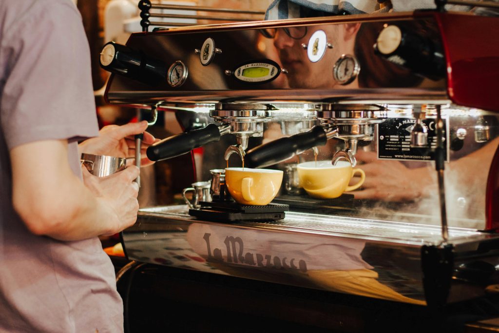 man making coffee with commercial espresso machine