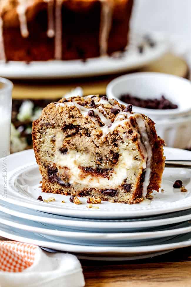 a close up of coffee cake on a stack of plates with white icing