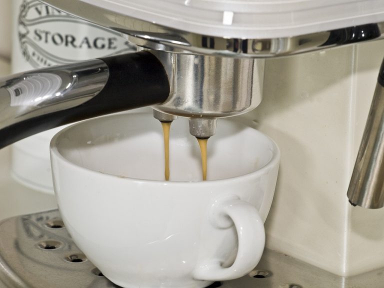 espresso dripping into a white coffee cup