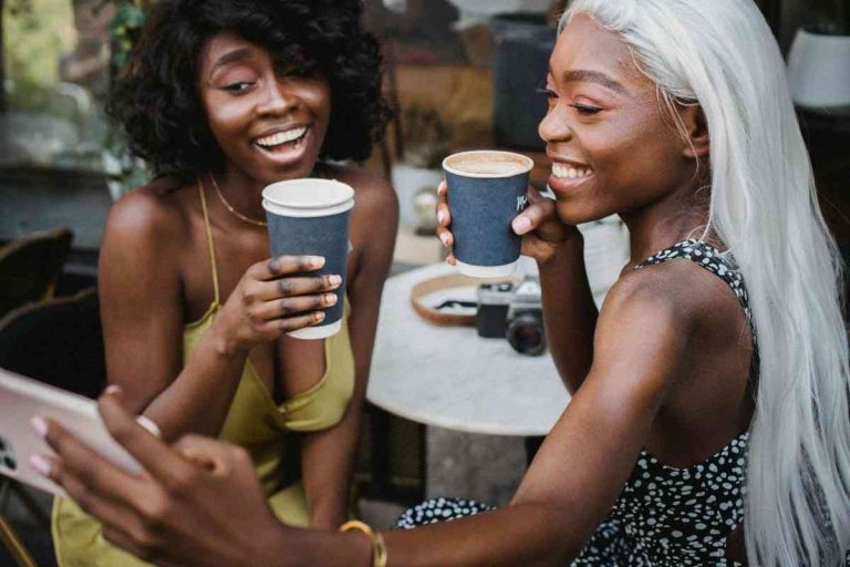 two friends taking a selfie with coffee