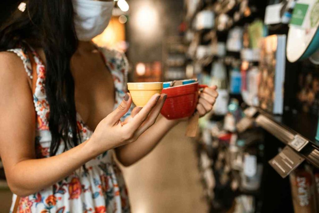 A person holding two cups in a retail store