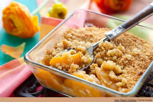 A close-up of a peach cobbler dessert resting on a spoon