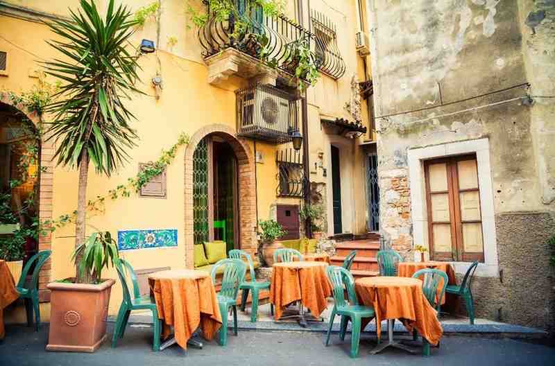 orange and teal colored outdoor seating at a cafe in Sicily